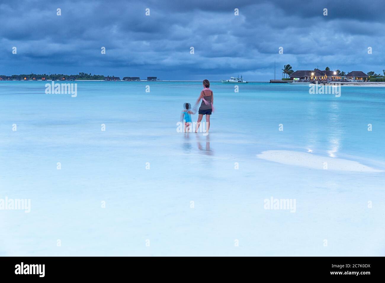 Mujer jugando con su hija en una playa paradisiaca isla Guraidhoo, Maldivas Antecedentes de un Resort de lujo Stockfoto