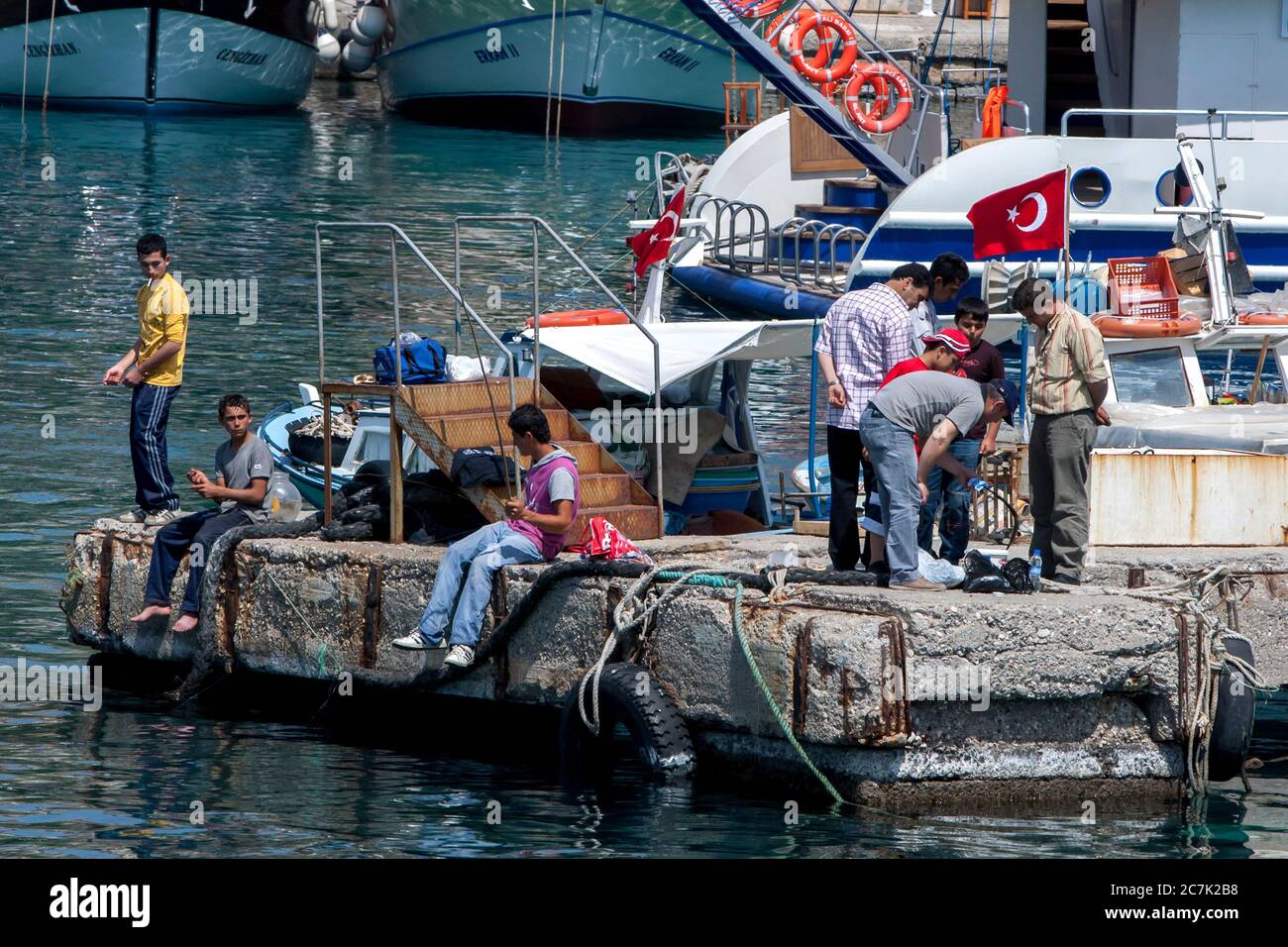 Fischer werfen ihre Leinen von einem Betonwharf im römischen Hafen in der Altstadt von Keleici in Antalya, Türkei. Stockfoto