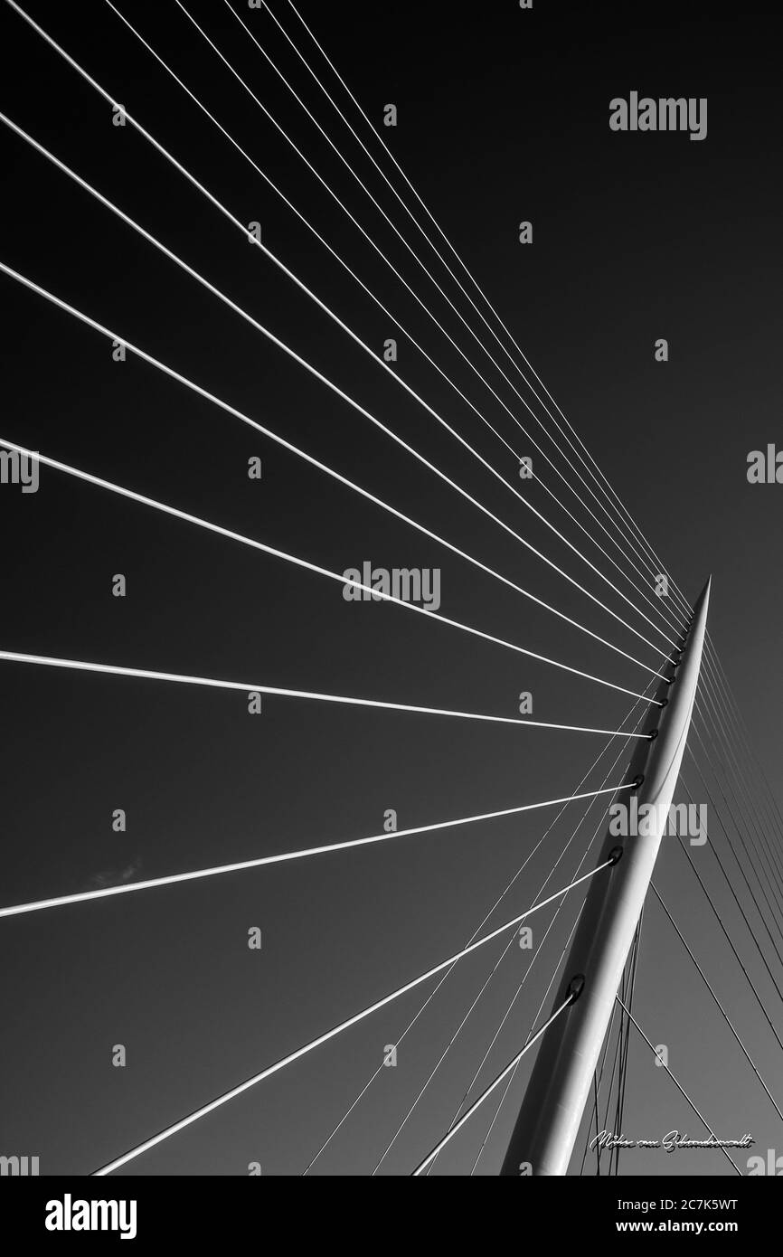 Vertikale Graustufenaufnahme einer kabelgestabeten Brücke Stockfoto