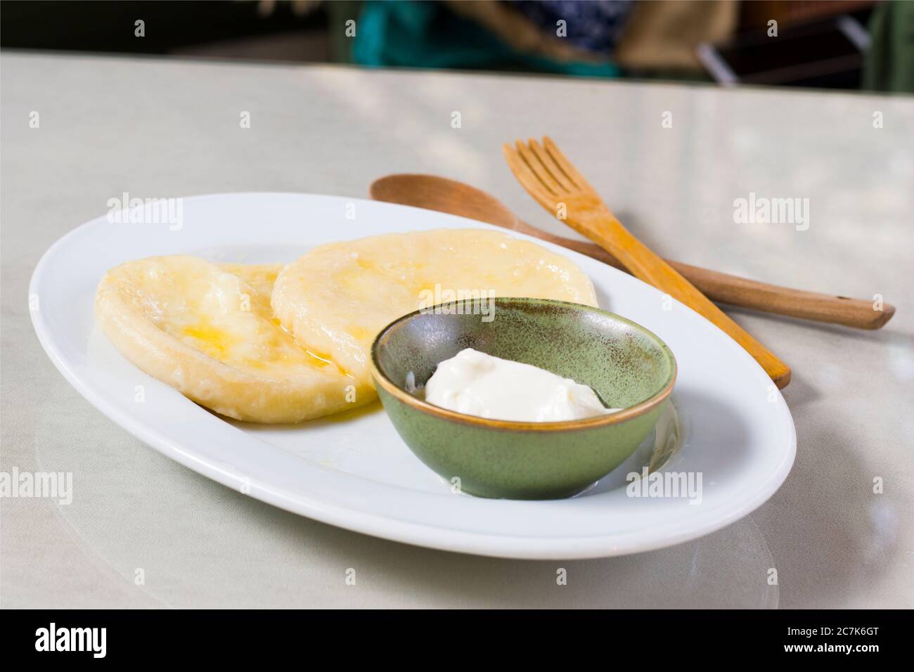 Käseknödel auf dem weißen Teller, in grüner Schüssel aufgesüßen. Traditionelle georgische Küche. Käse Khin. Stockfoto