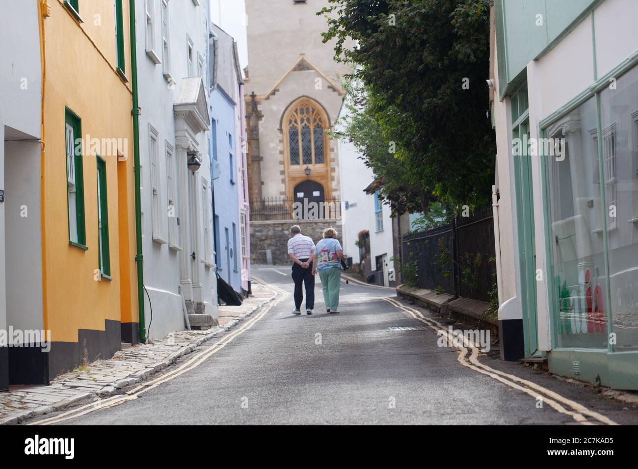 Rückansicht eines älteren Paares zu Fuß eine malerische Straße bei Lyme Regis, Dorset, Großbritannien Stockfoto