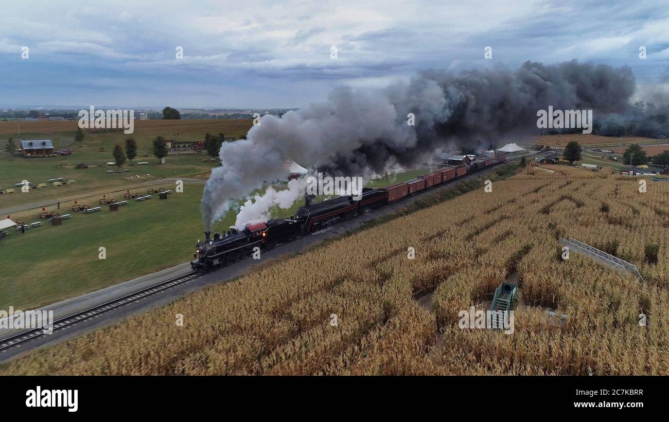 STRASBURG, USA - Oct 07, 2019: Luftaufnahme von Doppelkopfdampflokomotiven Puffing Black Smoke and Steam auf einem AUT durch die Landschaft Stockfoto