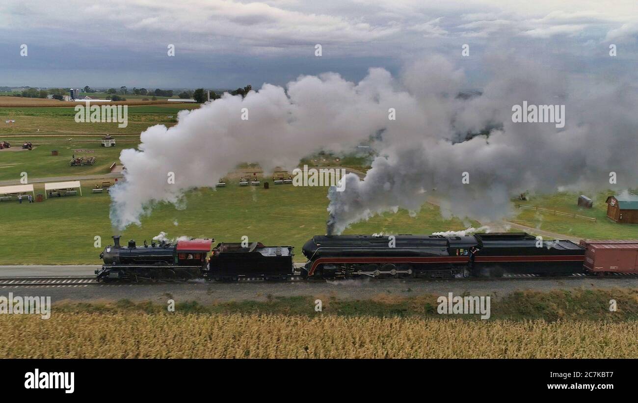STRASBURG, USA - Oct 07, 2019: Luftaufnahme von Doppelkopfdampflokomotiven Puffing Black Smoke and Steam auf einem AUT durch die Landschaft Stockfoto