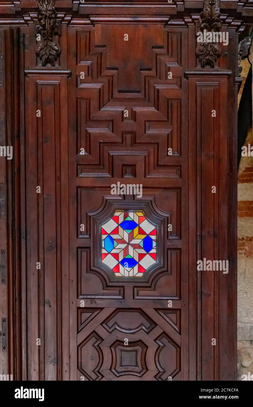 Ein farbenfrohes Buntglasfenster in einem geschnitzten Türrahmen aus Holz in der Moschee-Kathedrale von Cordoba. Stockfoto