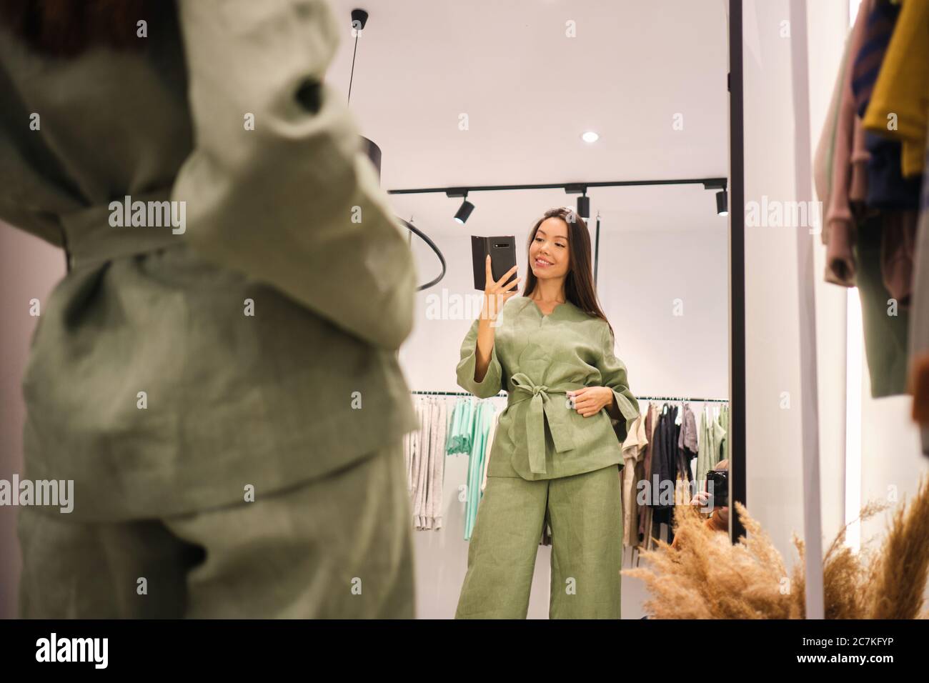 Schöne asiatische Mädchen versuchen auf stilvolle Anzug glücklich unter Selfie im Spiegel in der Garderobe der Kleidung zu speichern Stockfoto