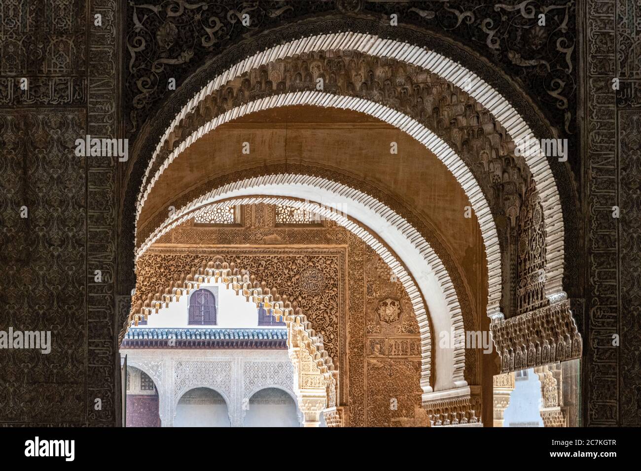 Hoch dekorative Hufeisen- und Polyfolienbögen führen vom Turm Comares zum Innenhof der Myrtles in der Alhambra von Granada Stockfoto