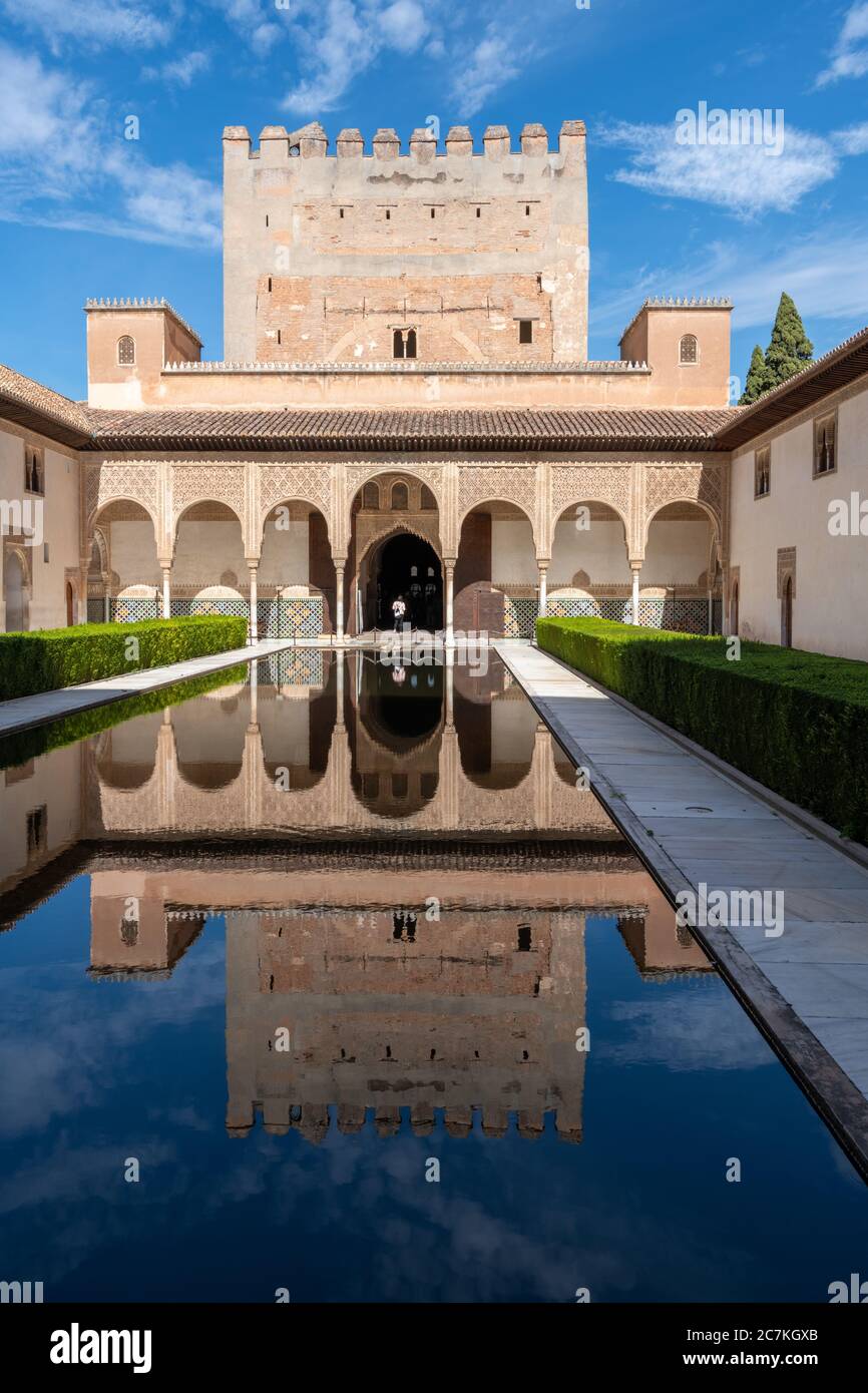 Ein Wasserspiegel im Innenhof der Myrtles spiegelt den zinnenbelähten Comares-Turm und die Nordgalerie des Comares-Palastes wider. Stockfoto