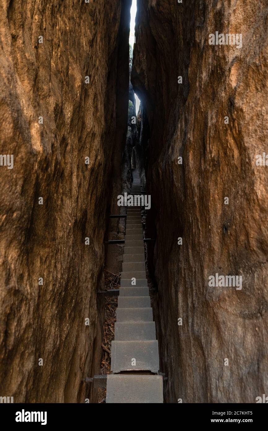 Vertikale Aufnahme von schmalen Treppen zwischen zwei großen Steinen in Eine Höhle Stockfoto