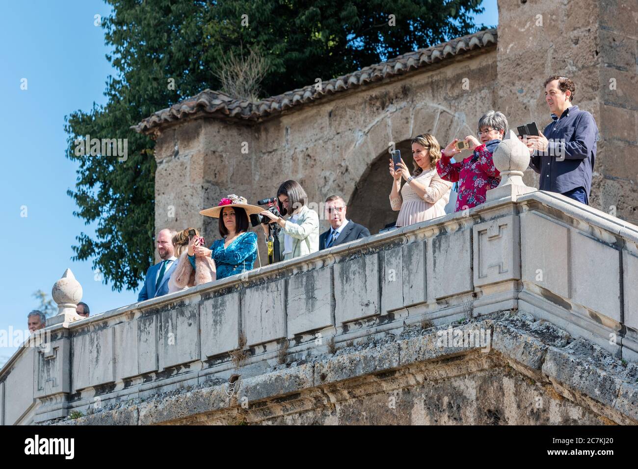 Hochzeitsgäste beobachten und Filmen die Ankunft der Braut bei einer Hochzeit im Monasterio de la Cartuja in Granada Stockfoto