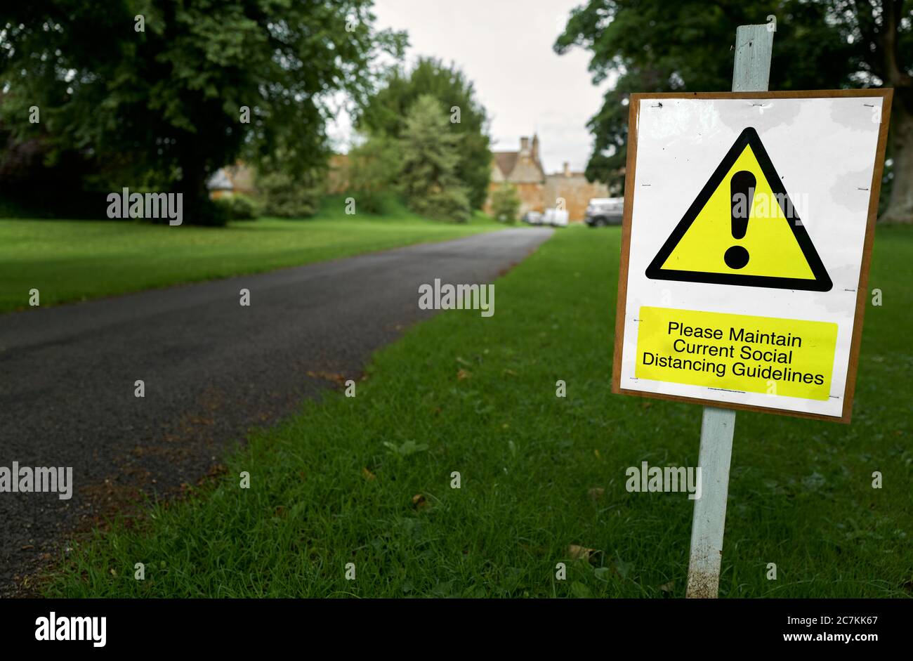 Beachten Sie bitten Besucher, ihre soziale Distanz auf dem Weg zu Rockingham Castle, Corby, England, während der Coronavirus-Krise zu halten. Stockfoto