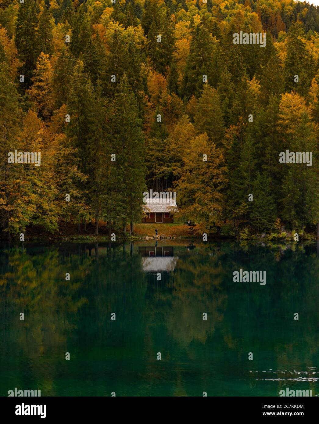 Schöne Reflexion von einem kleinen Haus und Bäumen in einem See. Herbstlandschaft in den italienischen Dolomiten. Stockfoto