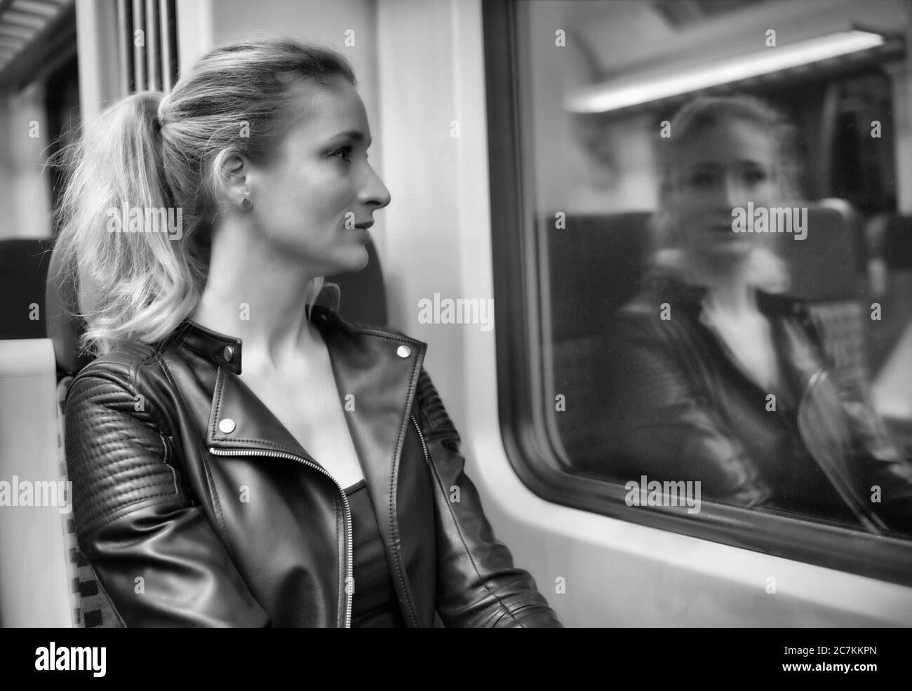 Frau ohne Gesichtsmaske, sitzt im Zug, reflektiert im S-Bahn-Fenster, Corona-Krise, Stuttgart, Baden-Württemberg, Deutschland Stockfoto
