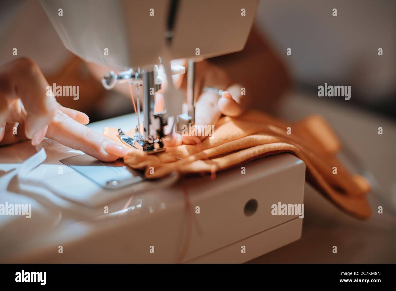 Frau nähen Gesichtsmaske für Corona covid Pandemie mit Nähmaschine, Stockfoto