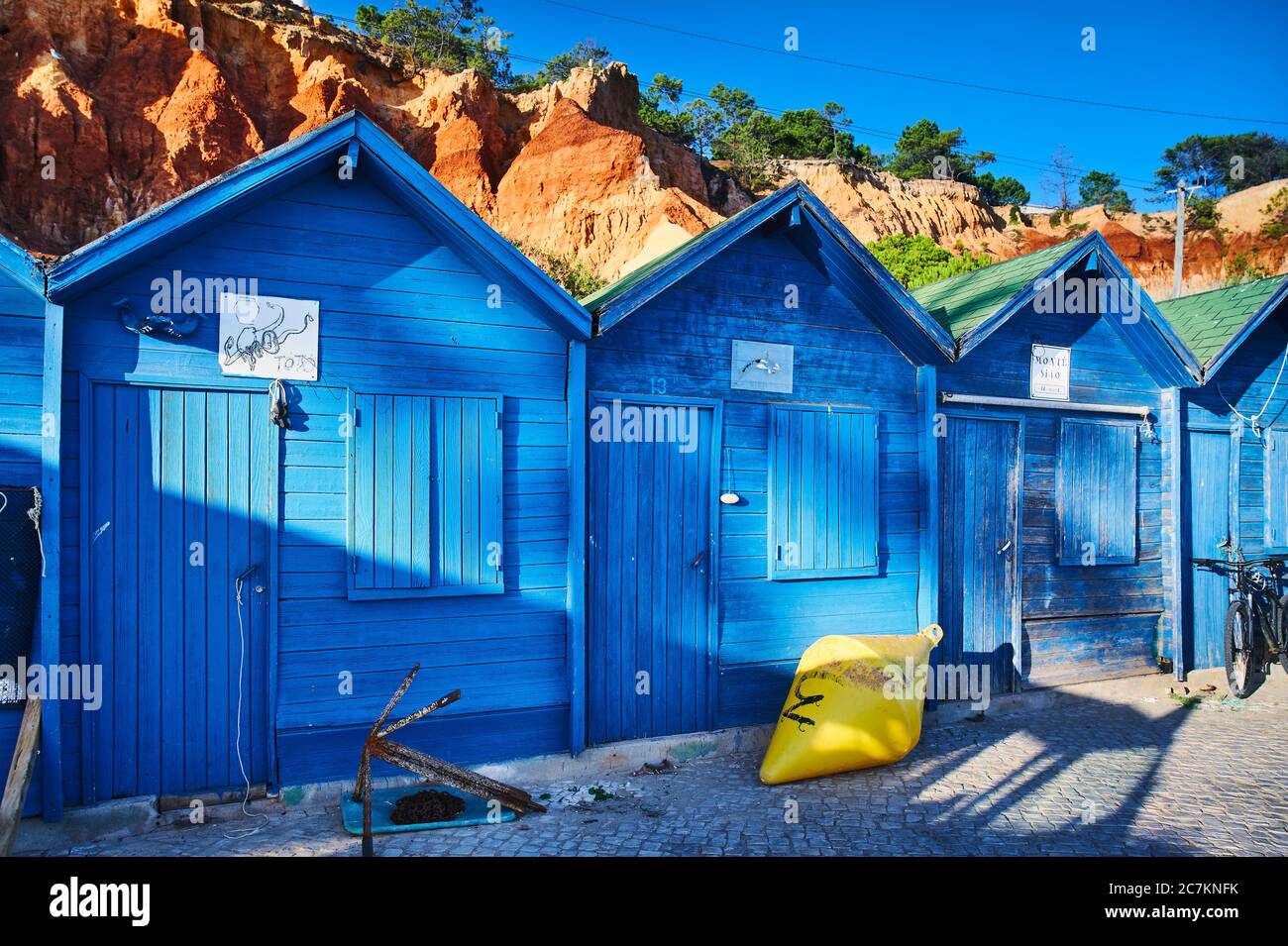 Europa, Portugal, Algarve, Litoral, Barlavento, Bezirk Faro, bei Albufeira, Praia dos Olhos de Agua, blaue Fischerhütten vor rotbraunen Klippen Stockfoto