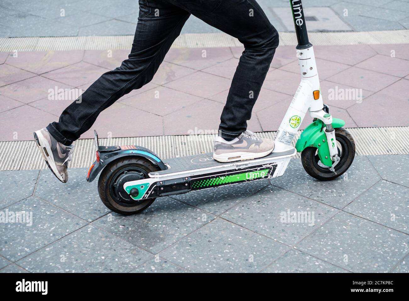 Berlin, Deutschland - Juli 2020: Nahaufnahme einer Person, die einen E-Scooter oder Elektroroller von Lime benutzt Stockfoto