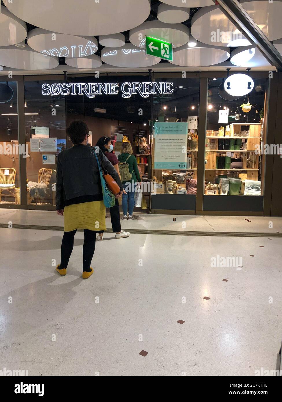 Menschen, die während Corona einkaufen, mit sicherer Entfernung, menschliche Schlange Stockfoto