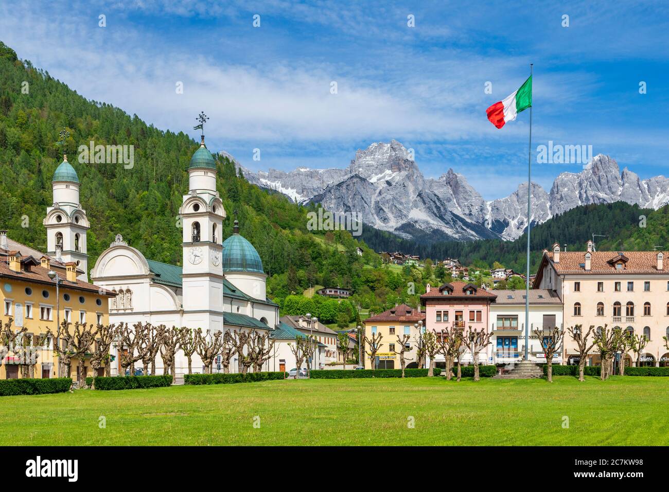 Das Zentrum von Agordo mit der Kirche mit zwei Glockentürmen und der großen grünen Wiese namens "broi", agordino, belluno, venetien, italien Stockfoto