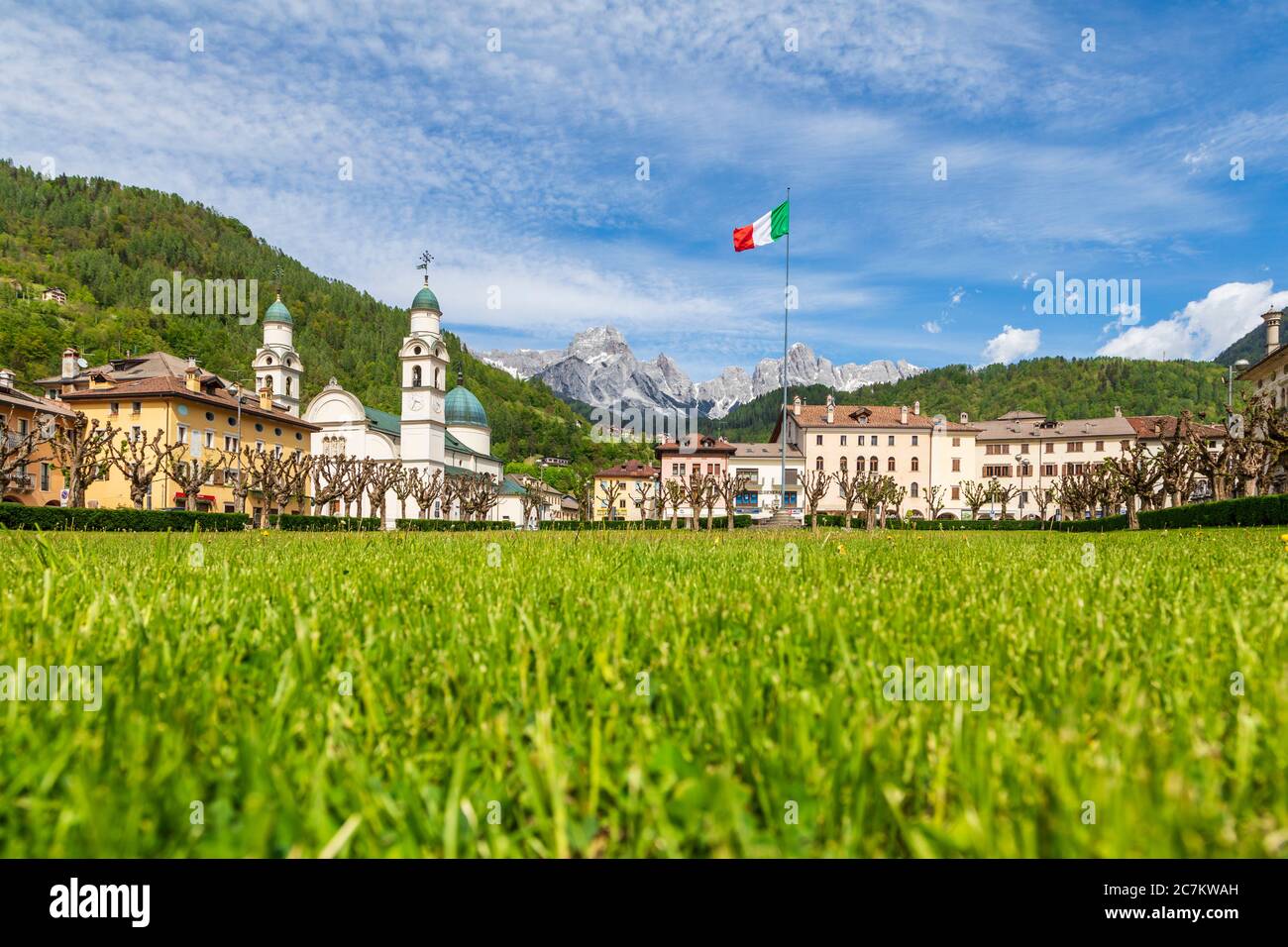 Das Zentrum von Agordo mit der Kirche mit zwei Glockentürmen und der großen grünen Wiese namens "broi", agordino, belluno, venetien, italien Stockfoto