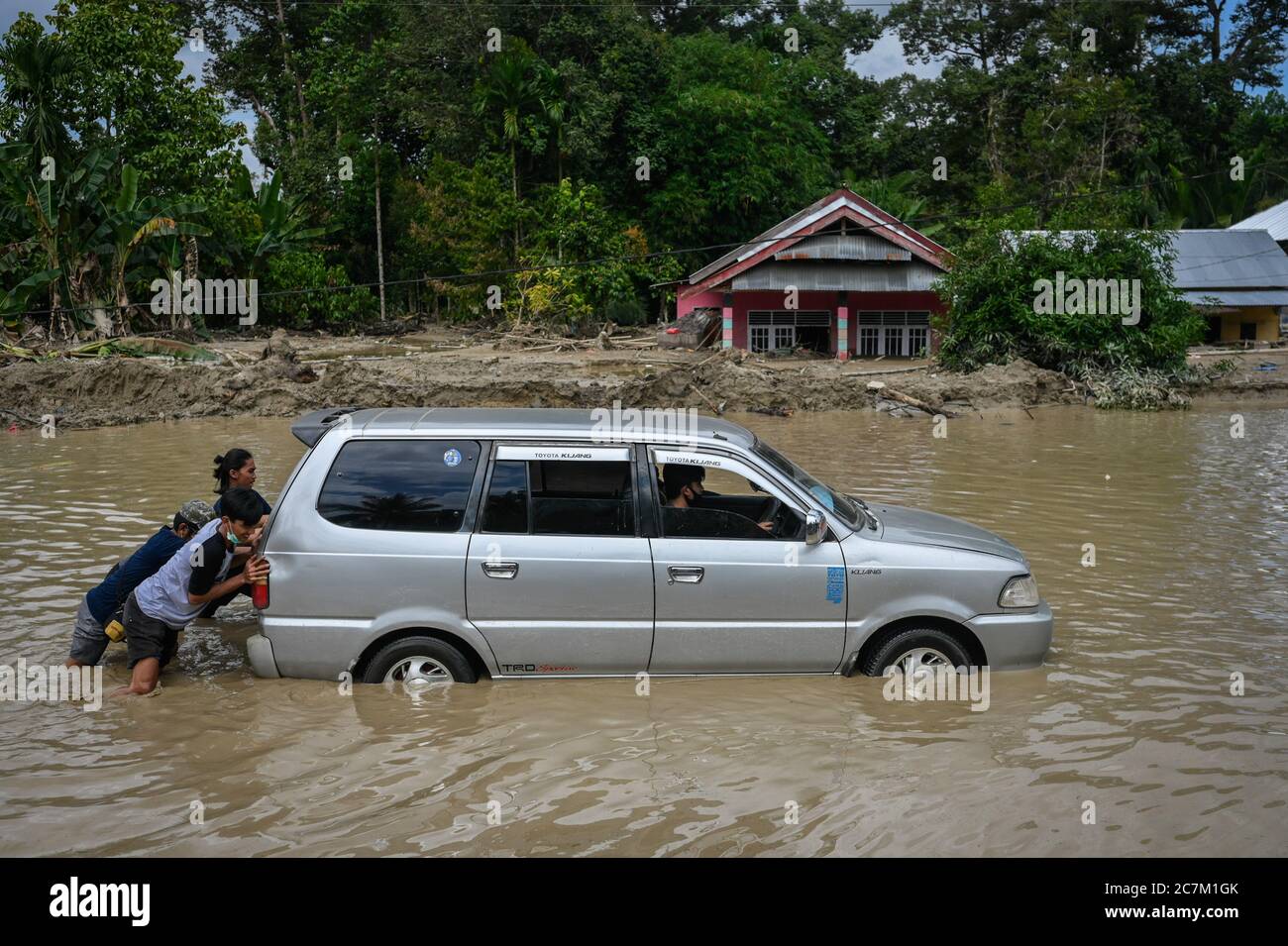 Masamba, Indonesien. Juli 2020. Bewohner schieben ein Auto in Wasser nach Sturzfluten durch Radda Dorf, Süd-Sulawesi, Indonesien, gefegt, mindestens 36 Menschen starben nach Sturzfluten in der Region vor 5 Tagen, das Rettungsteam weiterhin auf der Suche nach Dutzenden von Opfern, die noch vermisst werden. Kredit: SOPA Images Limited/Alamy Live Nachrichten Stockfoto
