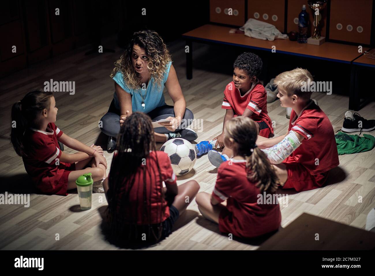 Coach Frau Fußball Kinder Fußballmannschaft. Trainer erklärt die Spielstrategie. Sport Fußball Bildung. Stockfoto