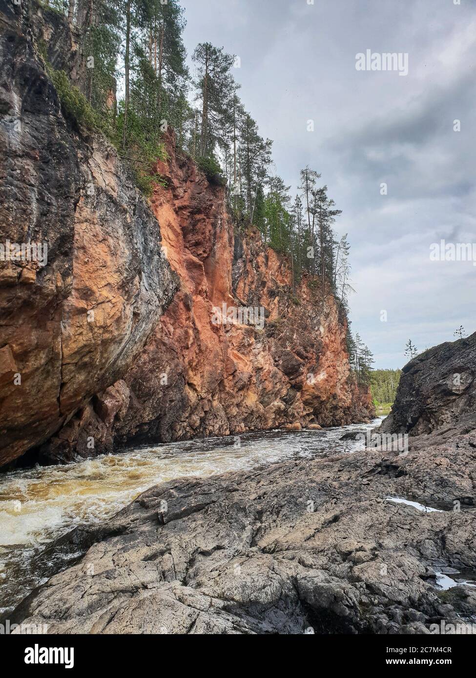 Vertikale Aufnahme eines Flusses mit einer schnellen Geschwindigkeit an Oulanka Nationalpark in Finnland Stockfoto
