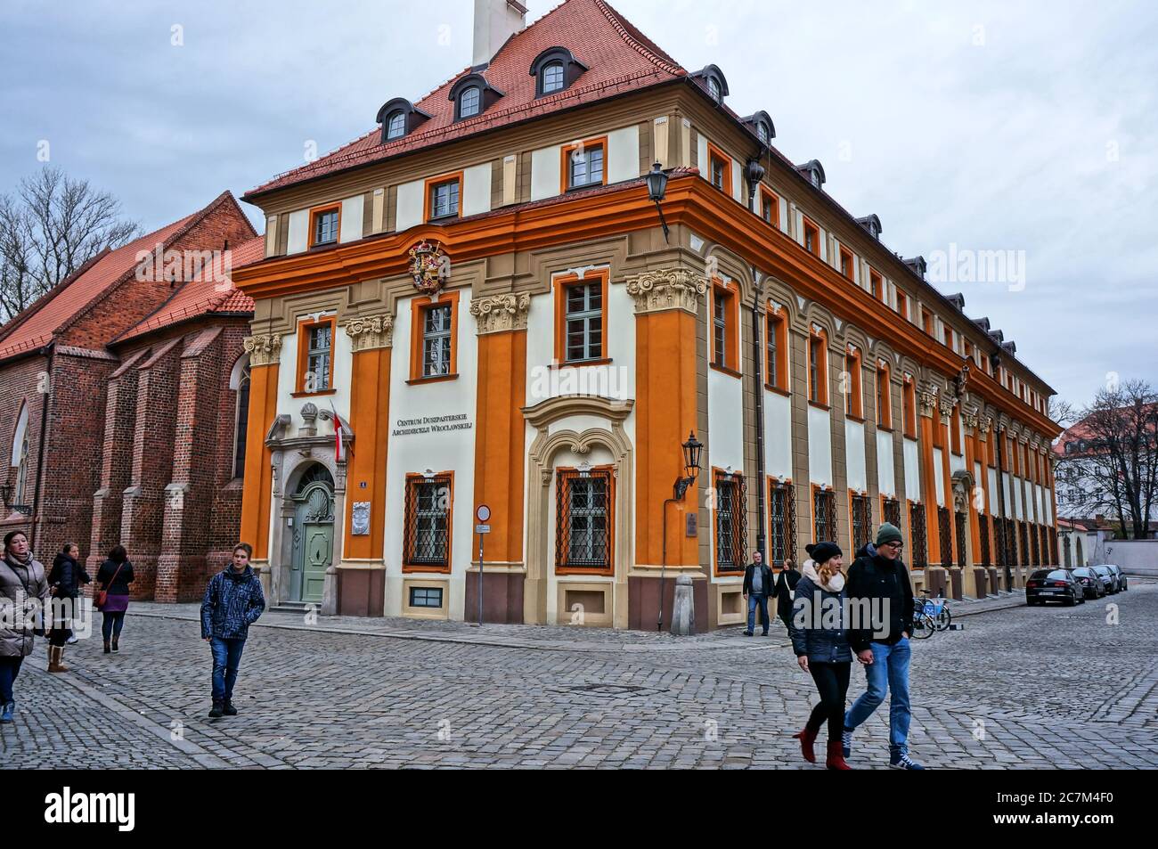 Leute laufen auf einer alten Straße mit Gebäude im Stadtzentrum. Stockfoto