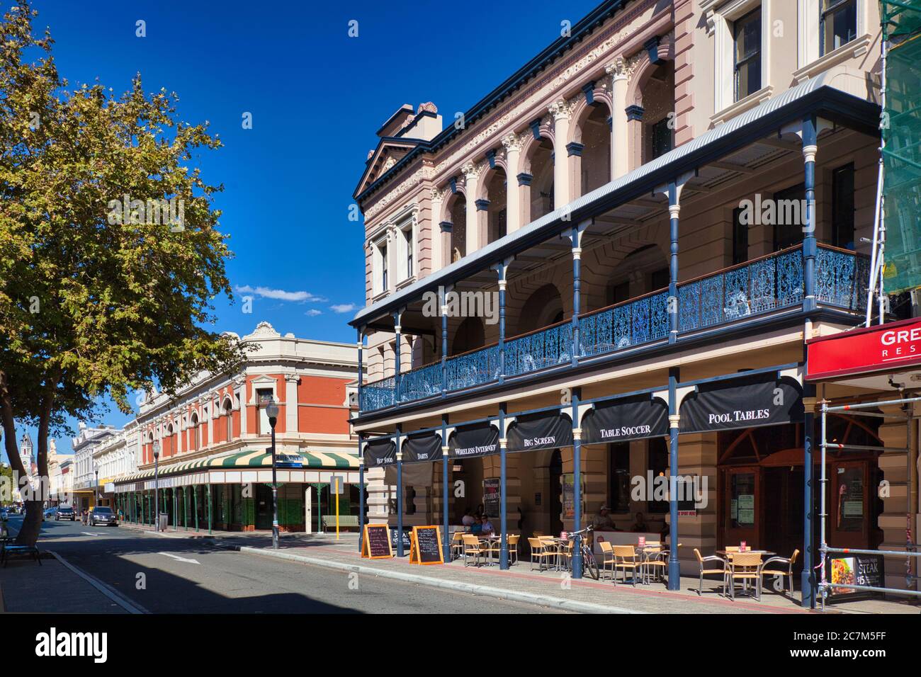 Typische Gebäude im älteren Stil mit Bögen und Veranden mit hübschen schmiedeeisernen Geländern an einer Straße in Fremantle, Westaustralien. Stockfoto