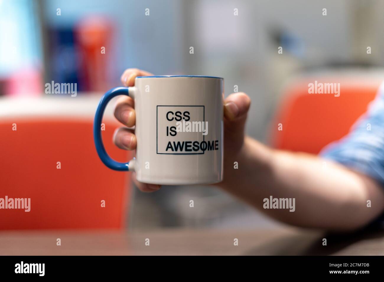 Selektive Fokusaufnahme einer Person, die eine Tasse mit hält Ein gedruckter Text von „CSS IS AWESOME“ Stockfoto