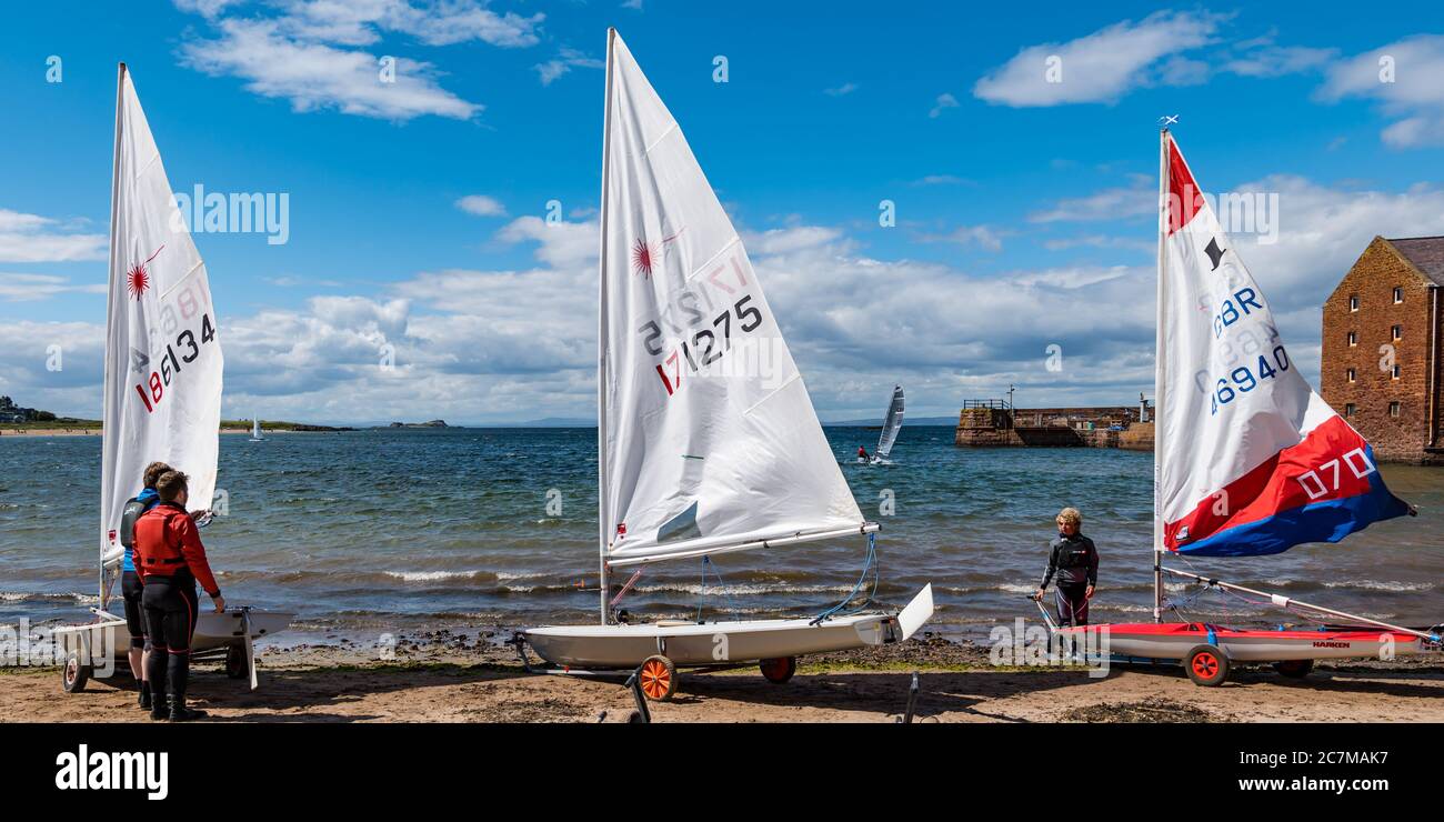 North Berwick, East Lothian, Schottland, Großbritannien, 18. Juli 2020. UK Wetter: Sommersonne in der Küstenstadt.das erste Rennen des East Lothian Yacht Club, das heute nach Lockdown Lockdown genannt "Lockdown Shakedown" stattfinden soll, wurde wegen der steifen Brise, die den Rettungsdienst gefährdet hätte, abgesagt. Einzelpersonen gingen in ihren Segeljollen vom West Bay Strand trotz des Windes aus Stockfoto