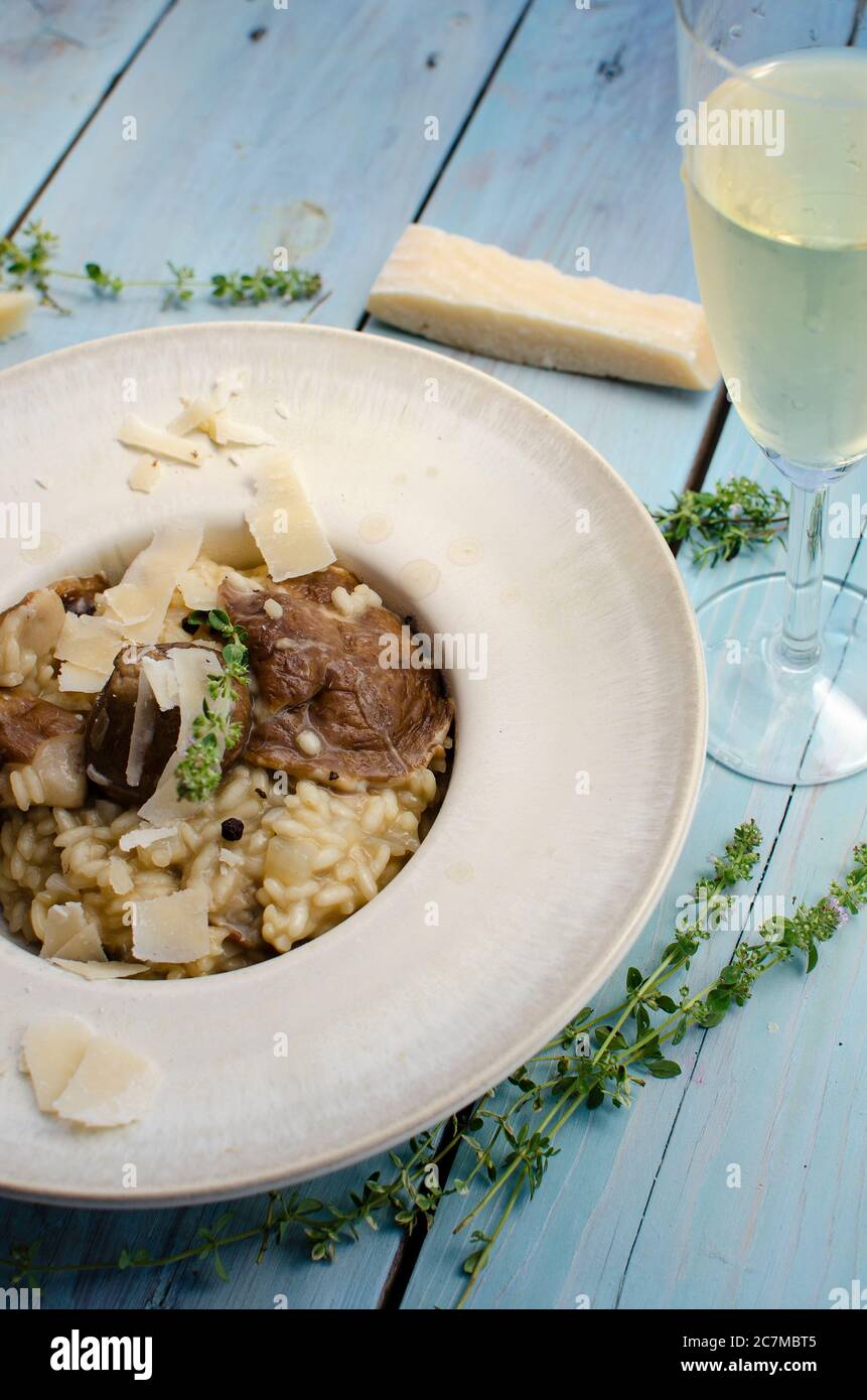 Risotto mit Steinpilz, Parmesan, Thymian und Weißwein auf Holzgrund Stockfoto