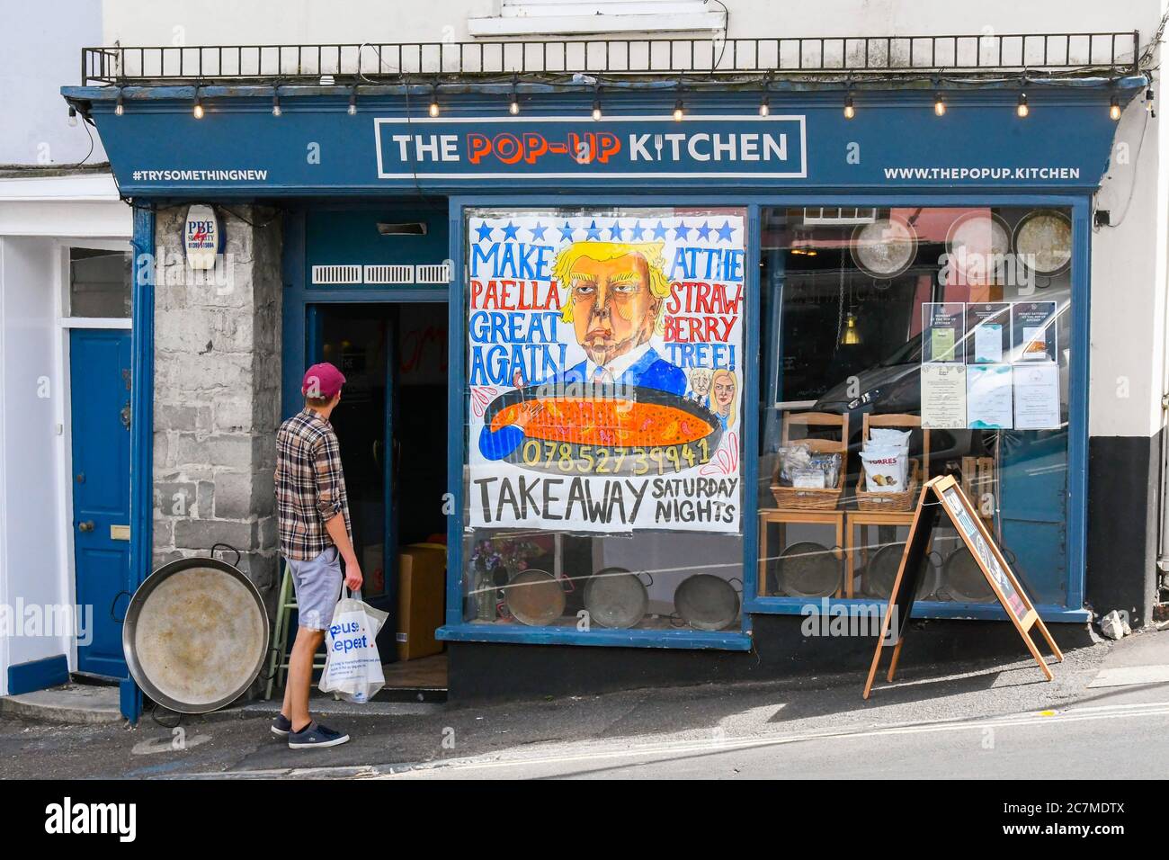 Lyme Regis, Dorset, Großbritannien. Juli 2020. Die Pop-up-Küche im Badeort Lyme Regis in Dorset hat ein großes Banner mit einem Cartoon-Bild von Präsident Donald Trump mit einem Slogan "Make Paella Great Again". Bildquelle: Graham Hunt/Alamy Live News Stockfoto