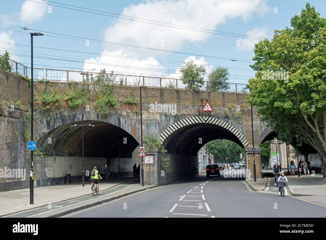 Eisenbahnbrücke über Hornsey Road mit Radwegen und Radfahrern auf beiden Seiten, Lower Holloway, N7, London Borough of Islington. Stockfoto