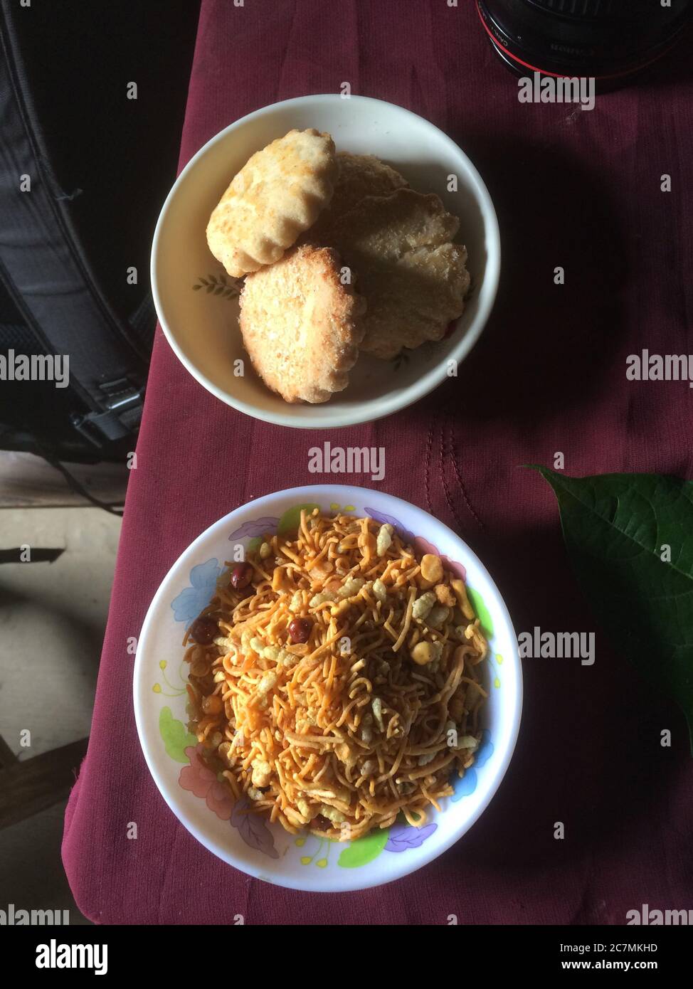 Snacks für die Passanten werden auf einem Tisch in Manikganj, einer kleinen Stadt außerhalb von Dhaka, Bangladesch, serviert, bestehend aus lokal hergestellten Keksen und ‘Chanachur’ (eine gewürzte Mischung aus Reis und Gramm Mehl, gemischt mit Erdnüssen). Stockfoto