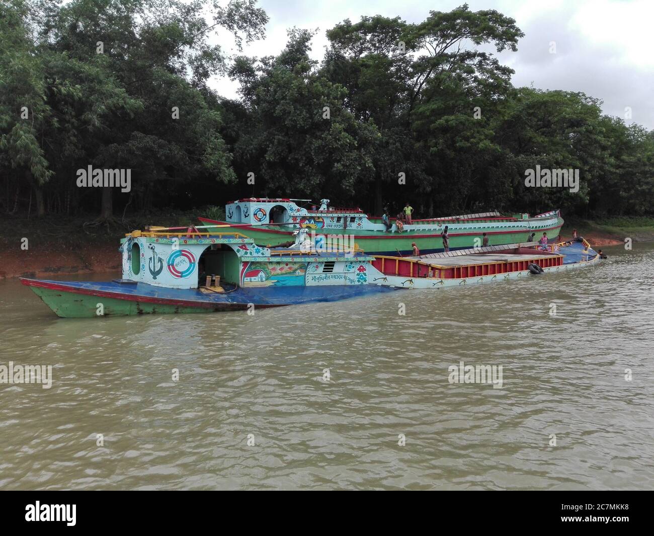 Bunt bemalte Frachtboote, die Sand auf dem Fluss Turag in Gazipur, Bangladesch transportieren. Stockfoto