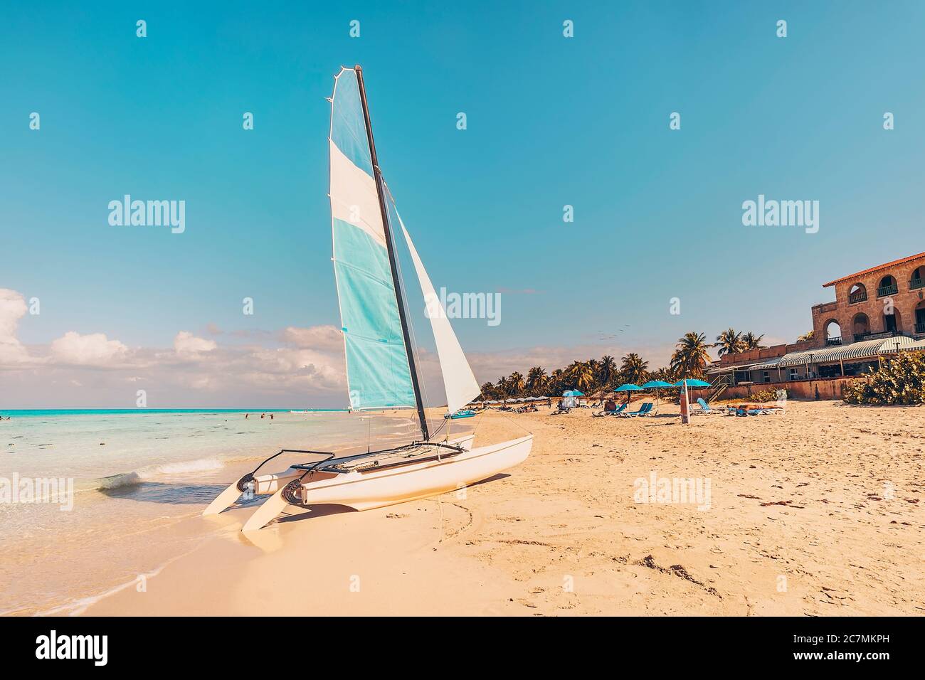 Weißer Katamaran blaues Segel auf weißem Sandstrand mit Retro-Effekt. Strand von Varadero in Kuba Stockfoto