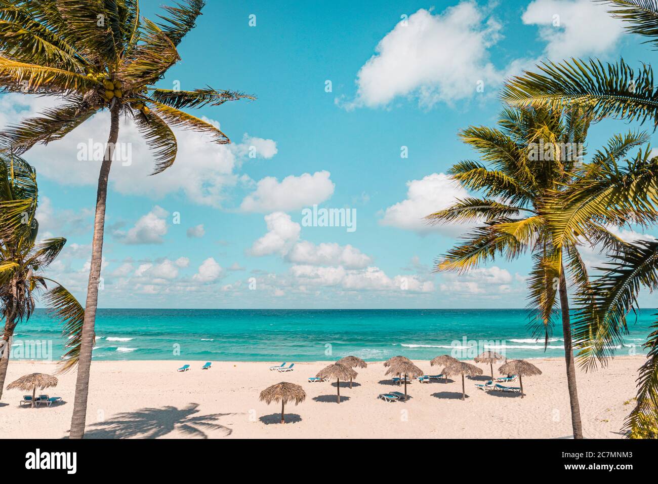 Varadero an einem sonnigen Tag. Wunderschöner Urlaub. Schöner Strand mit Liegen, Strohschirmen und Palmen. Luxus-Strand vor dem Hintergrund Stockfoto