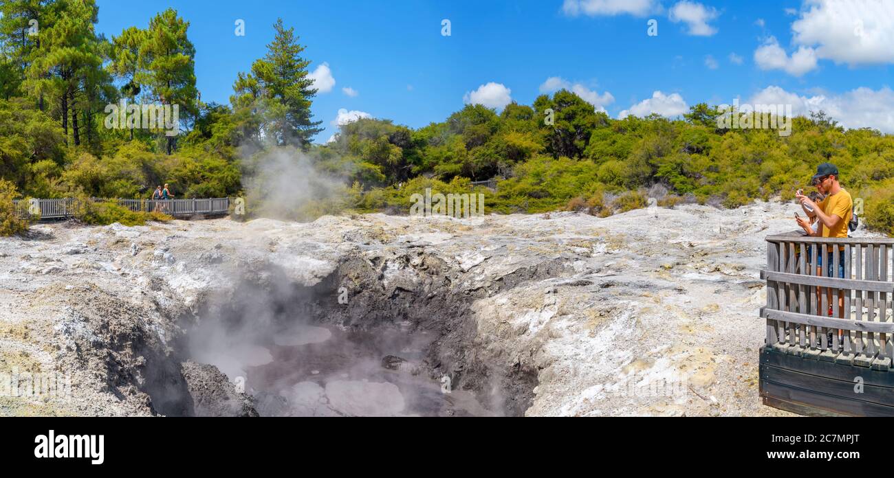 Paar fotografiert einen Schlammpool im Wai-O-Tapu Thermal Wonderland, in der Nähe von Rotorua, Neuseeland Stockfoto