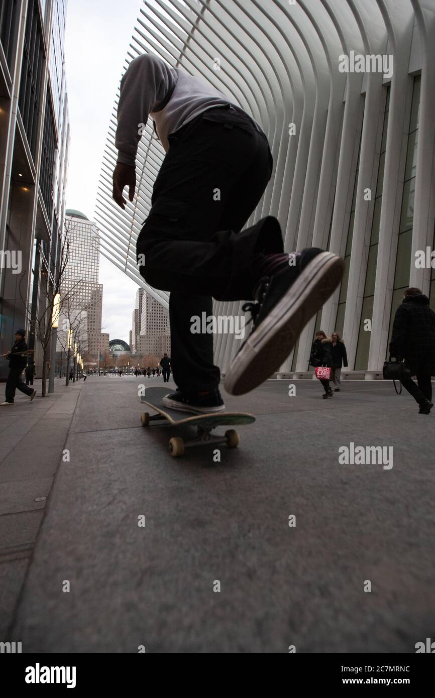 NEW YORK, USA - 26. Jan 2020: Ein Mann, der in New York City auf und ab auf seinem Skate reitet, vor dem Occulus Building, wo der Welthandel CE Stockfoto