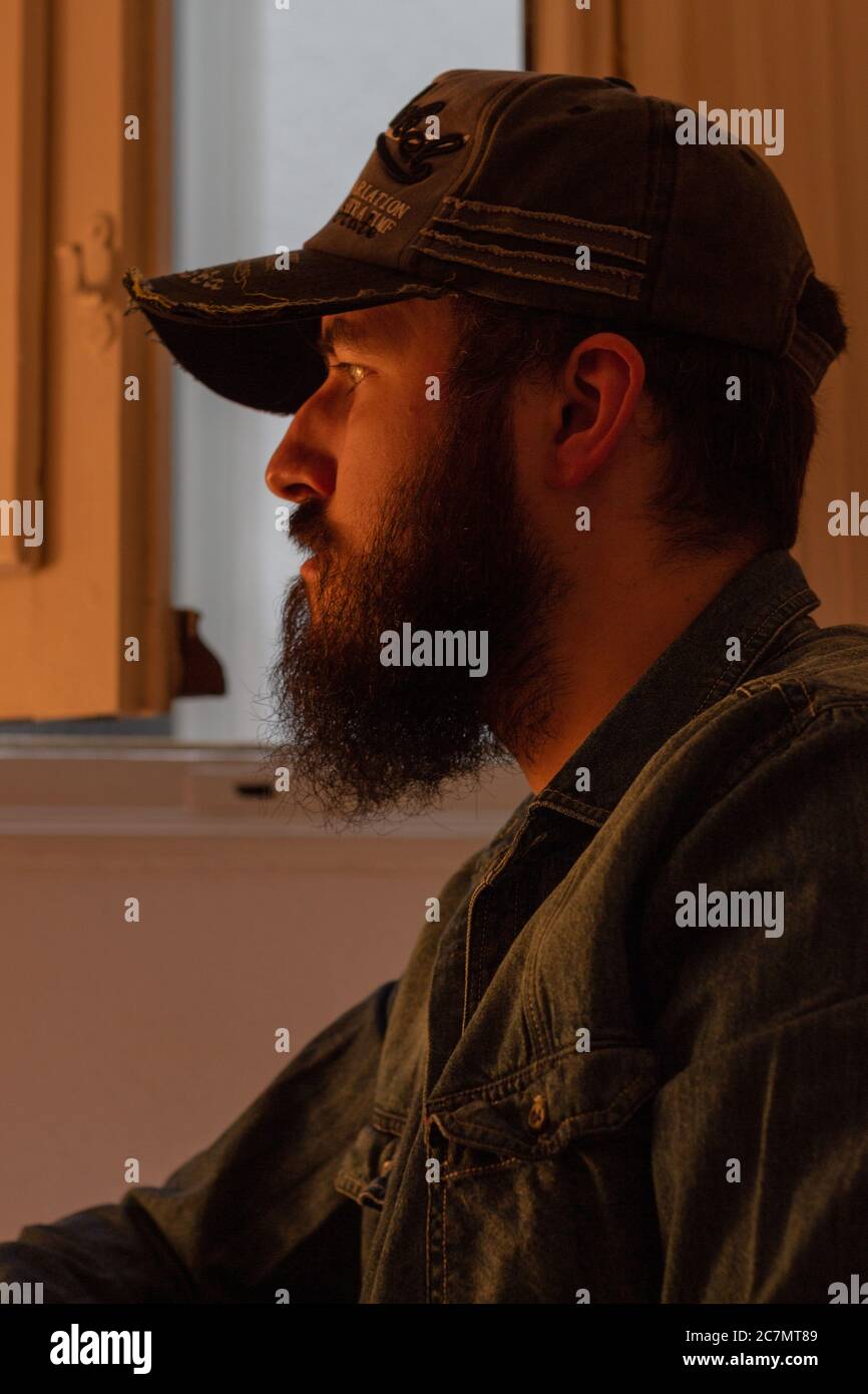 Attraktiver bärtiger Mann mit Hut und Blick auf etwas Stockfoto