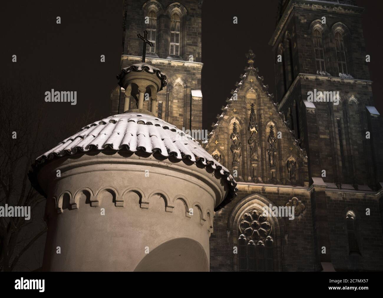 Basilika St. Peter und Paul, Vysehrad, Prag, Tschechien / Tschechien - kleine Kapelle und große gotische Kirche im Hintergrund während der Nacht Stockfoto