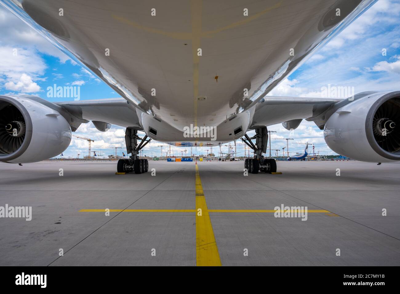 Unter dem Bauch eines weißen Boeing 777-200-Flugzeugs auf dem Vorfeld des Frankfurter Flughafens geparkt Stockfoto