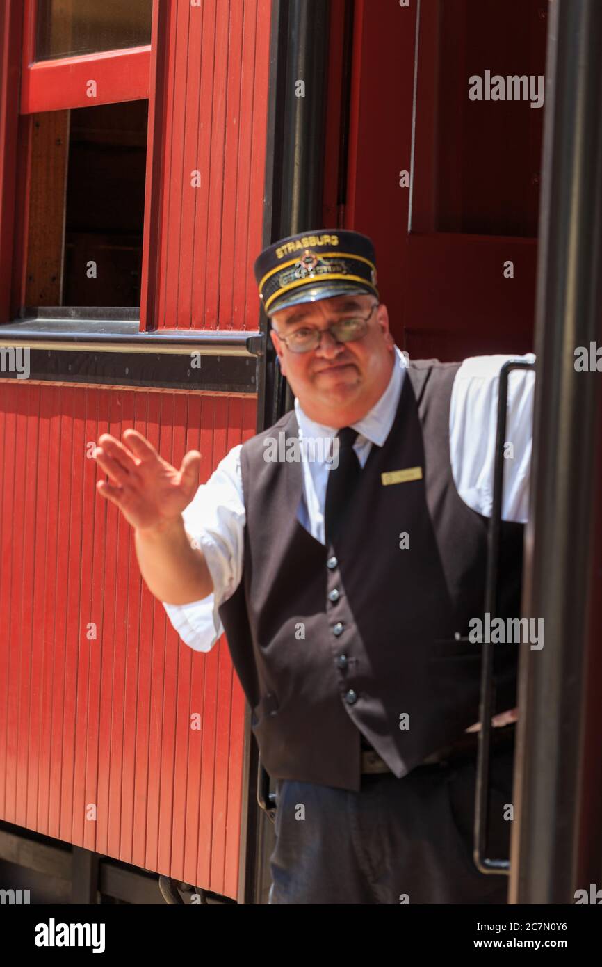 Strasburg, PA, USA - 20. Juni 2017: Ein Zugbegleiter wackgt am Bahnhof in Strasburg, Lancaster County. Stockfoto