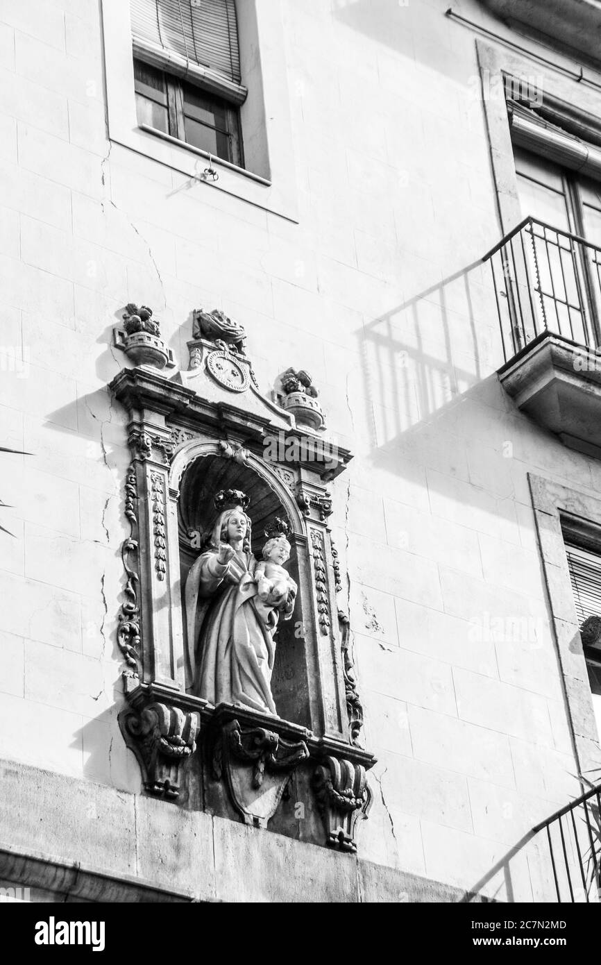 Eine religiöse Statue an der Außenwand einer Kirche: Barcelona, Spanien. Stockfoto