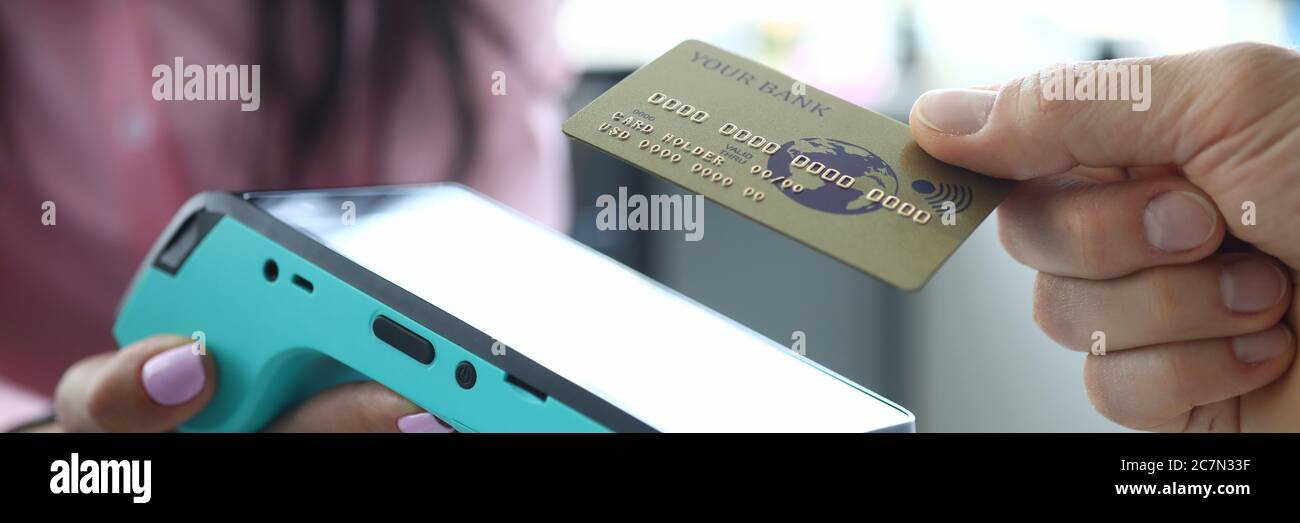 Man hält kontaktlose Kreditkarte zum Terminal Stockfoto