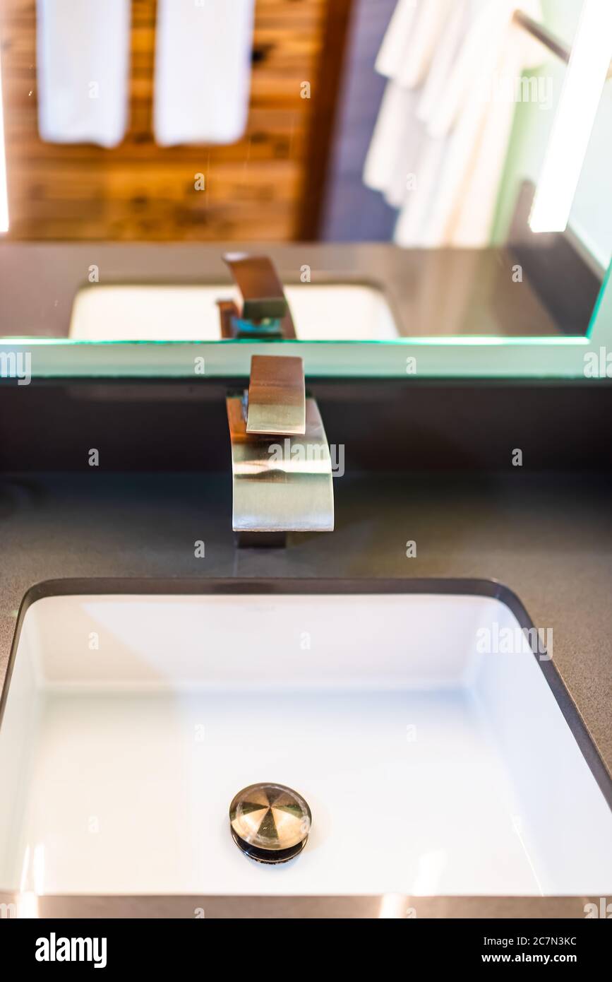 Neue moderne zeitgenössische Wasserhahn in Bad Nahaufnahme mit Edelstahl Chrom Griff und weißen Waschbecken mit Spiegelreflexion im Haus vertikale vie Stockfoto