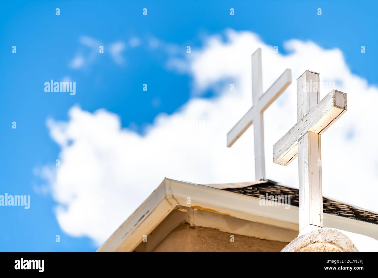 Ranchos de Taos Nahaufnahme der Kirche San Francisco de Asis Dachkreuz auf Turm mit Kreuz in New Mexico niedrigen Winkel Blick auf blauen Himmel Stockfoto