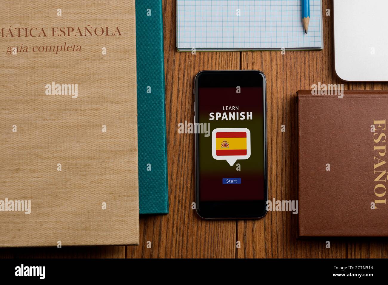 Spanisch lernen App und Lehrbücher auf Holztisch Stockfoto