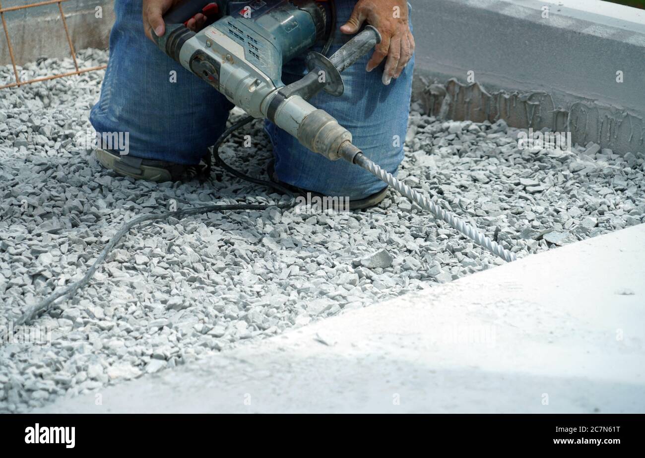 Manuelle Arbeiter Betrieb Bohrmaschine, um die Straße zu reparieren Stockfoto