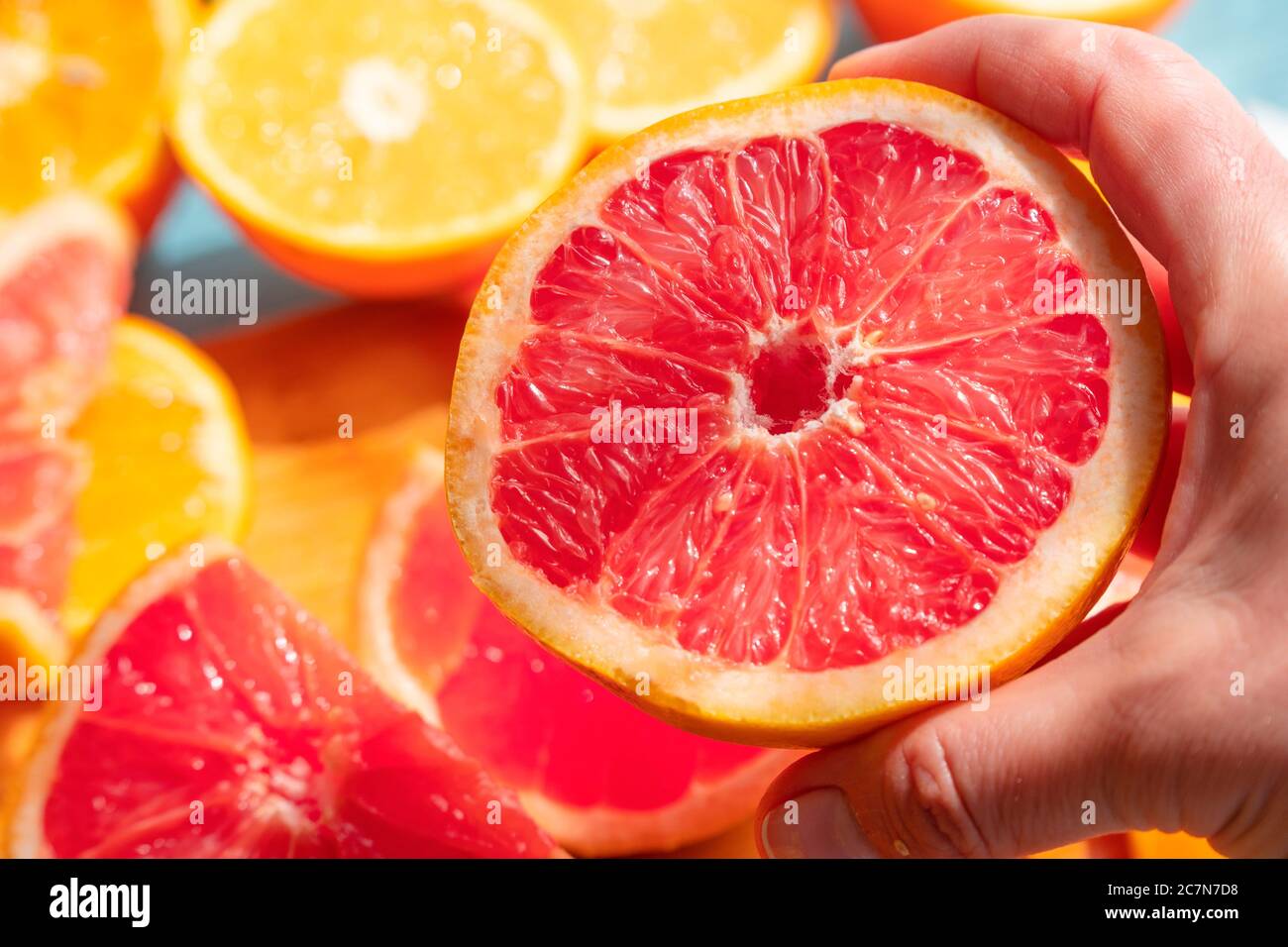 Frisch geschnittene Grapefruit und Orangenscheiben mit blauem Holzhintergrund. Stockfoto