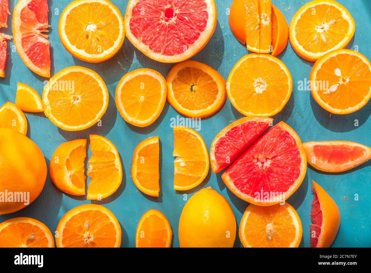 Frisch geschnittene Grapefruit und Orangenscheiben mit blauem Holzhintergrund. Stockfoto